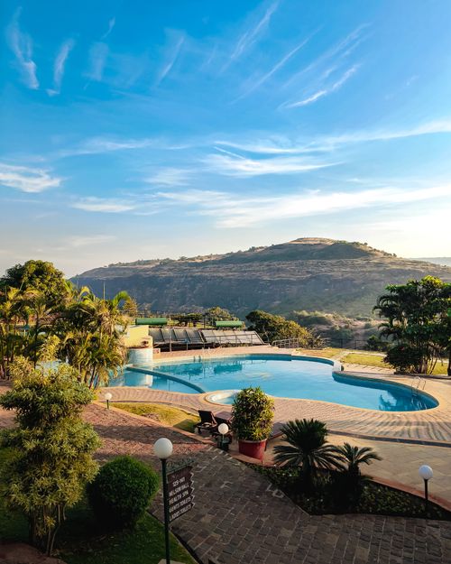 Free A tranquil resort with a swimming pool nestled in Lonavala's lush hills. Stock Photo