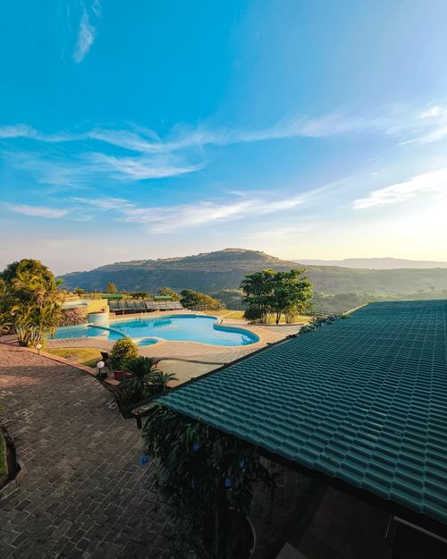 Free Beautiful view of a swimming pool and hills in a resort in Lonavala, India, perfect for relaxation. Stock Photo