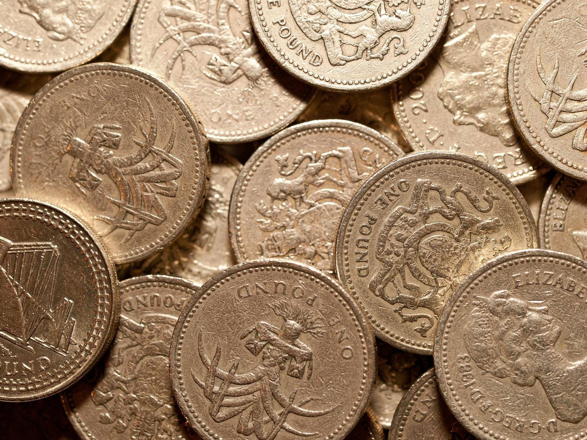 Macro shot of golden British pound coins showcasing intricate designs and details.