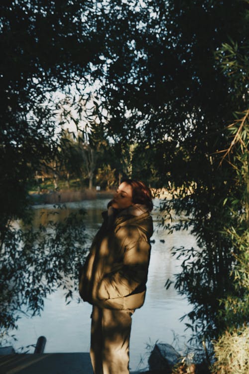 Woman Wearing Jacket Standing by the Lake 