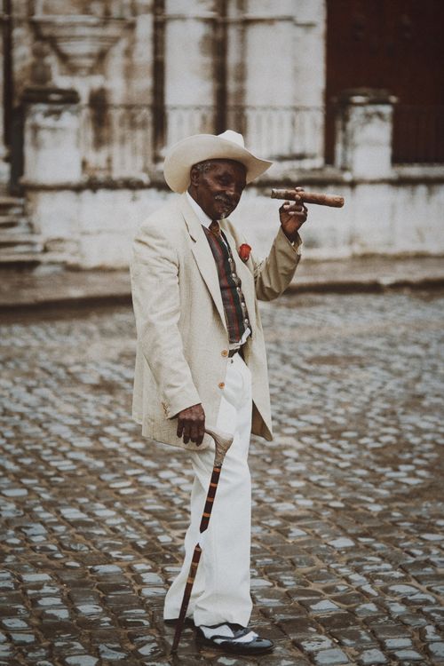 Free Elegant senior man in white suit smoking a cigar outdoors, showcasing style and confidence. Stock Photo