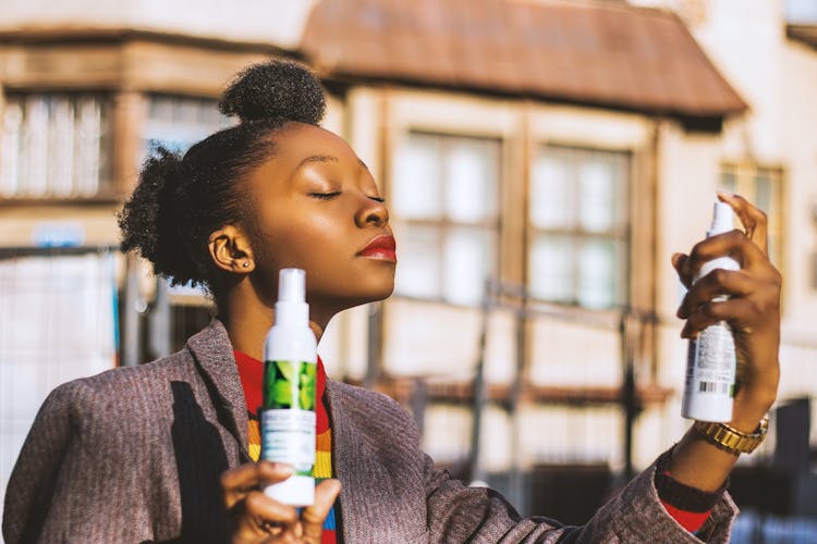 Woman Holding Two White Spray Bottles