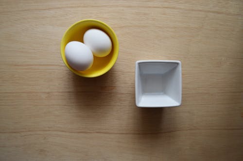 Twee Witte Eieren In Gele Keramische Kom