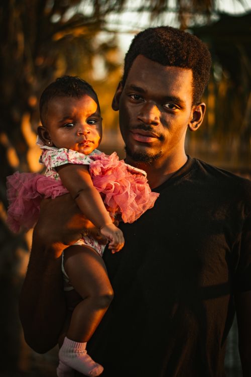 Free A father holding his baby daughter outdoors at sunset in Tampa, Florida. Stock Photo