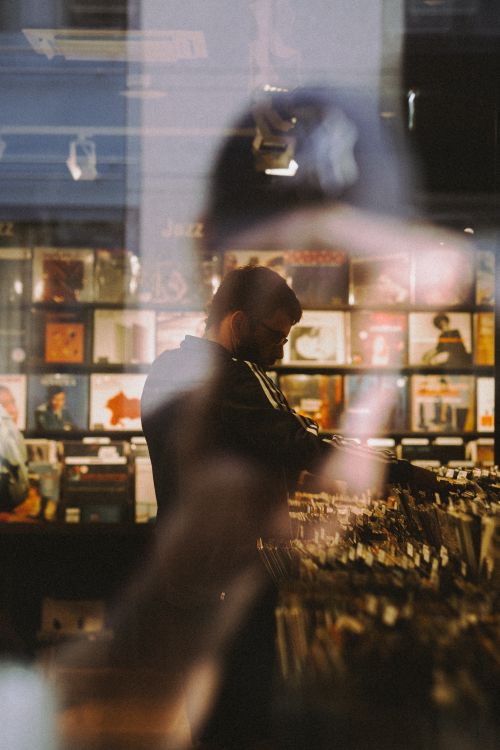 Free A man browsing a record store in Berlin with reflections on the window. Stock Photo