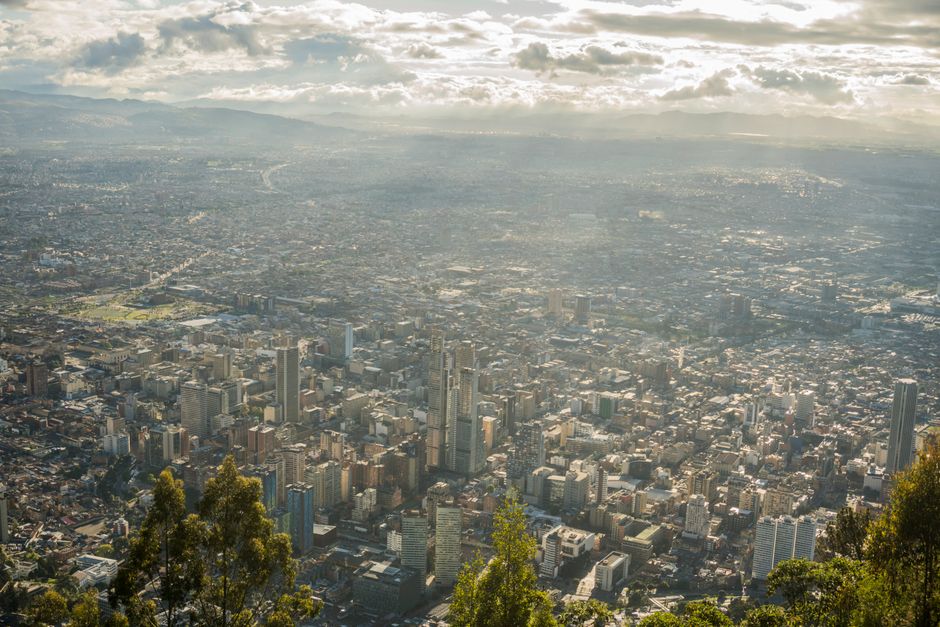 Stunning aerial view of Bogotá's urban landscape under a cloudy sky.