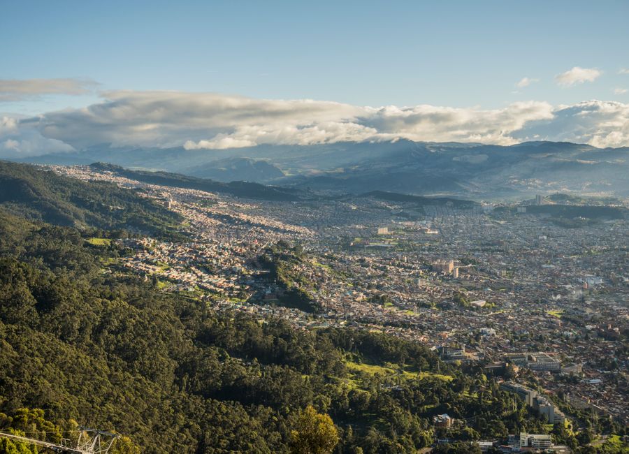 Aerial shot of Bogotá, Colombia, showcasing cityscape and surrounding lush mountains.