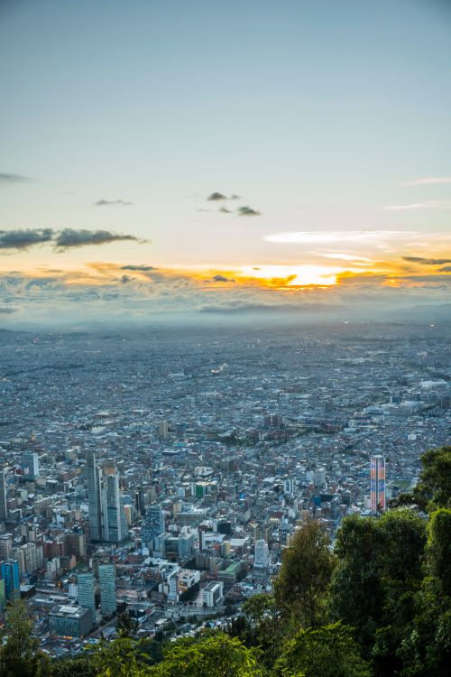 Free A breathtaking aerial view of Bogotá at sunset with vibrant cityscape and lush greenery. Stock Photo