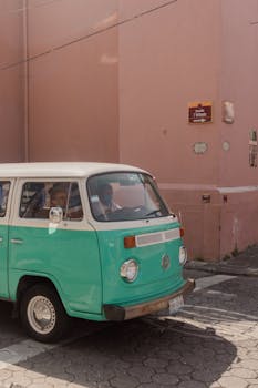 A classic green Volkswagen van on a sunlit street in Puebla, Mexico.