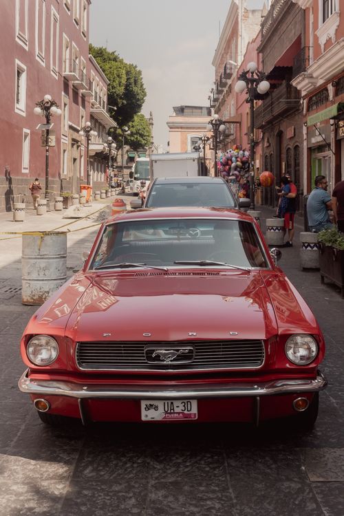 Free Classic red Ford Mustang parked on a lively street in Heroica Puebla, Mexico. Stock Photo