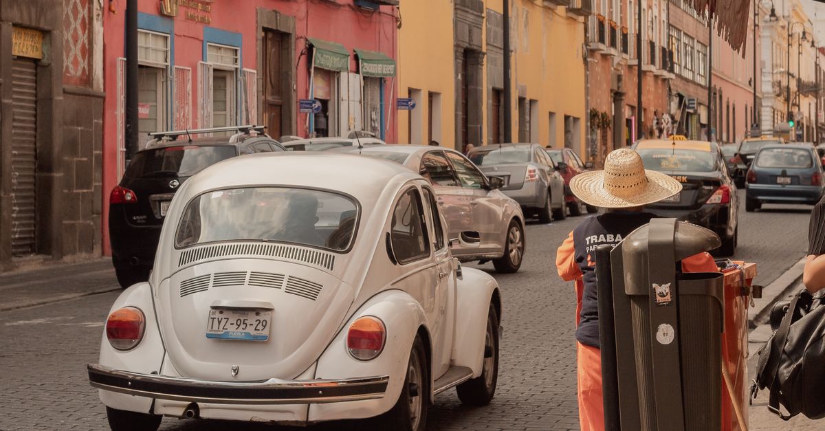 Hispanic man holding Mexican driver's license next to a car in Corpus Christi Texas