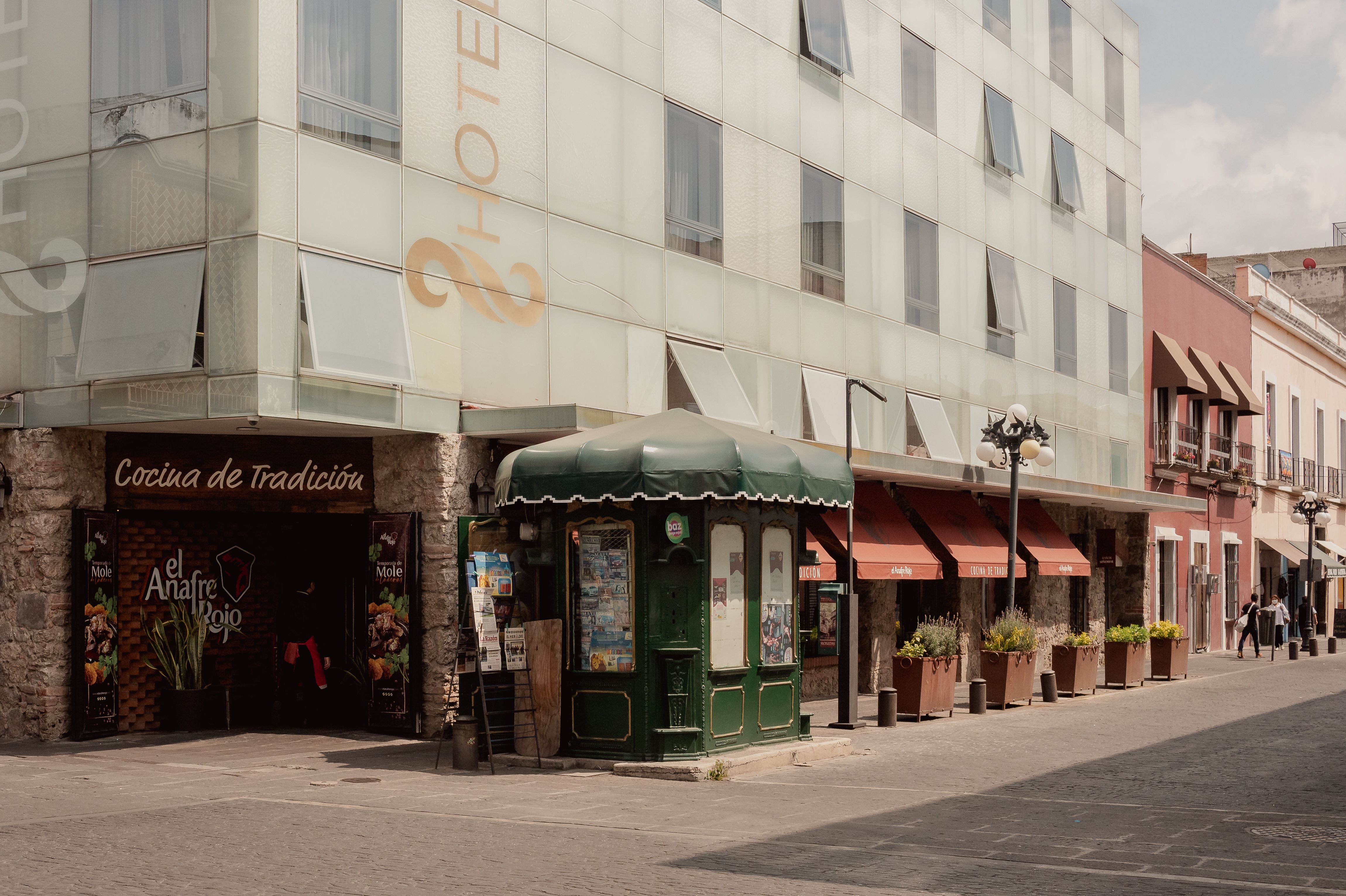 A charming street corner in Heroica Puebla de Zaragoza, Mexico, showcasing traditional architecture and local businesses.