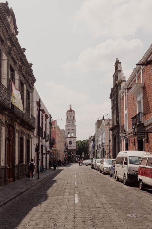 Free Charming sunlit street in Puebla, Mexico, showcasing historic architecture and urban life. Stock Photo