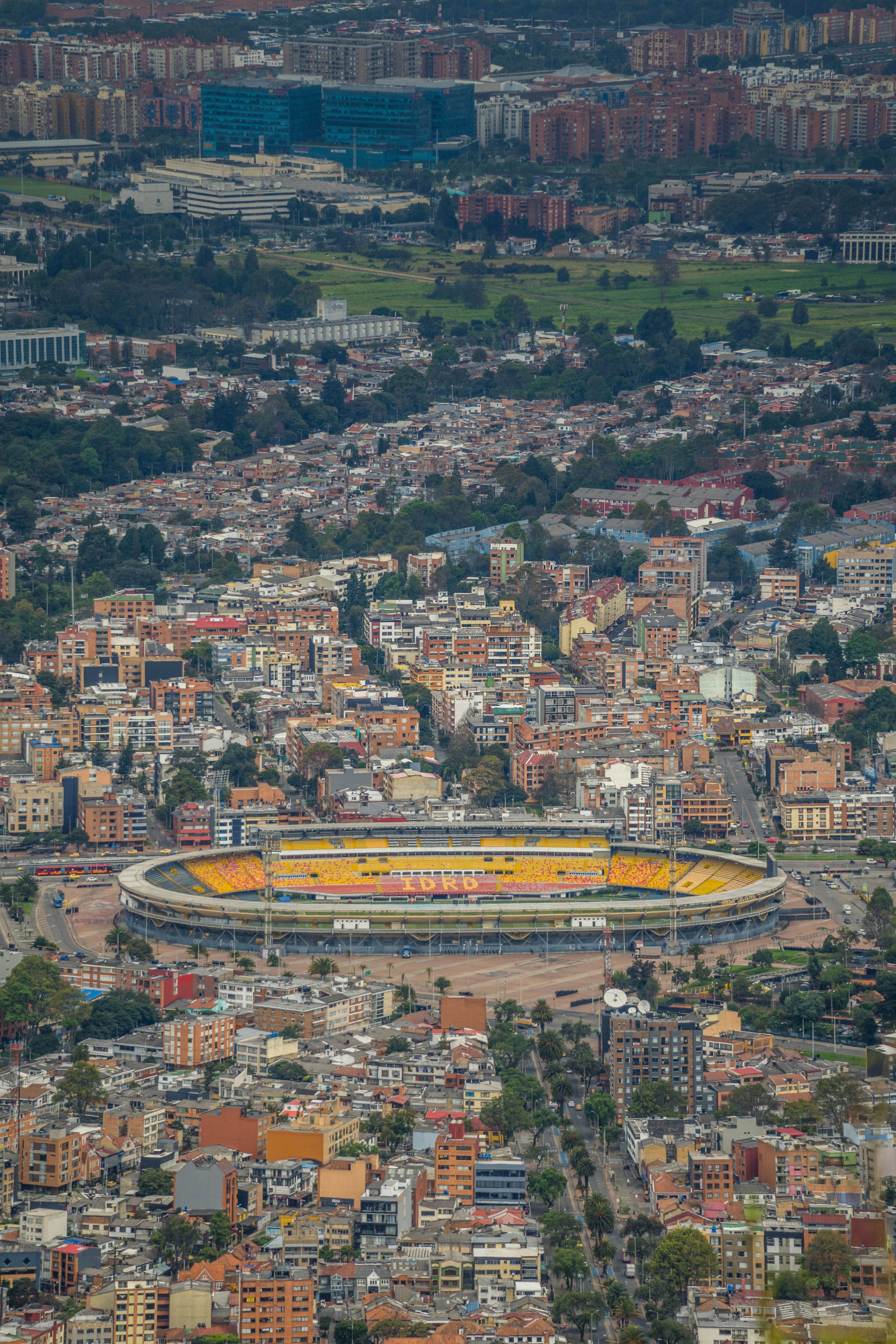 Stunning aerial view of Bogotá, Colombia featuring a prominent stadium and urban architecture.