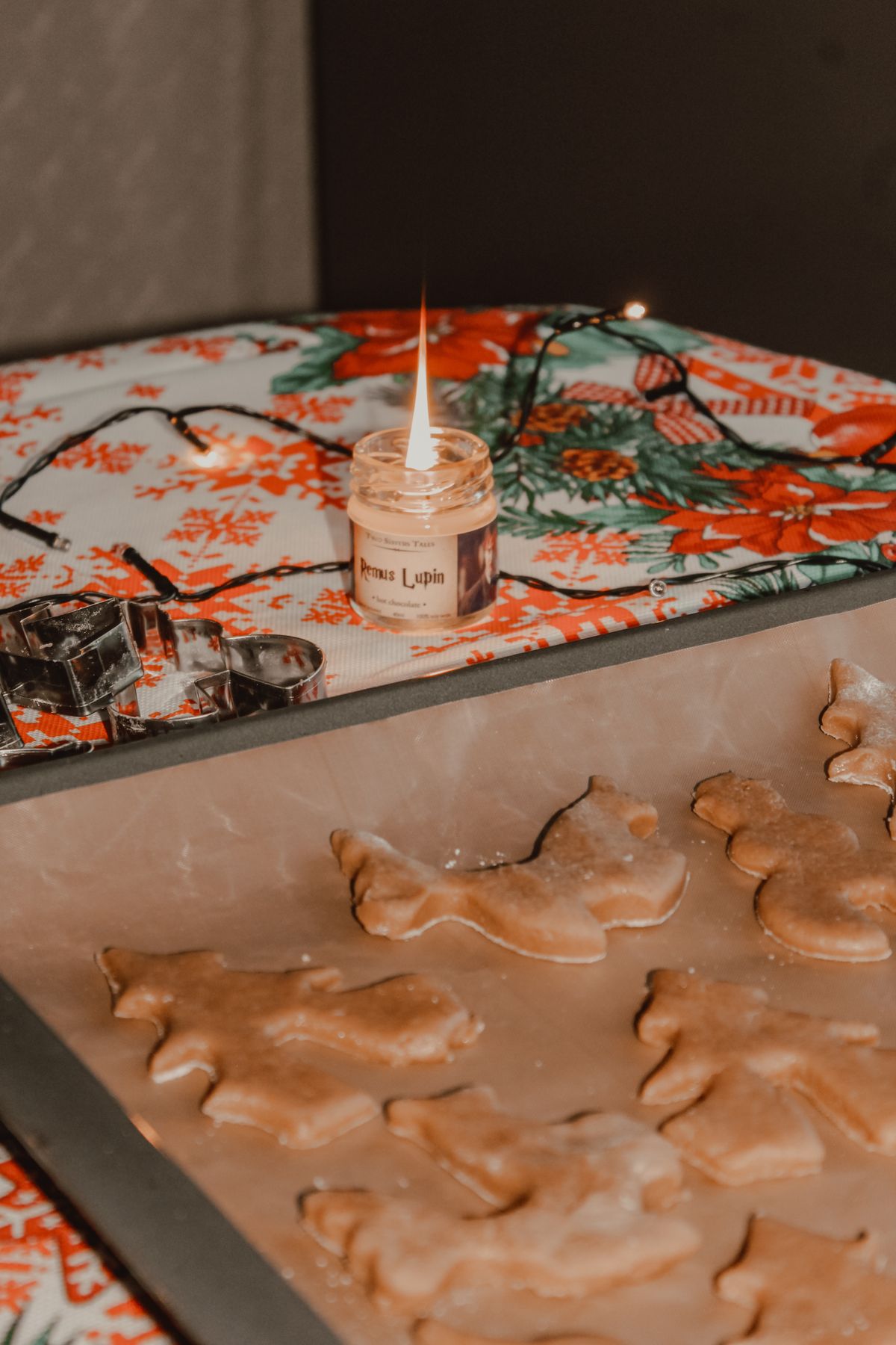 Holiday baking setup with cookie dough on the counter, warm string lights and a lit candle on bake-and-freeze day