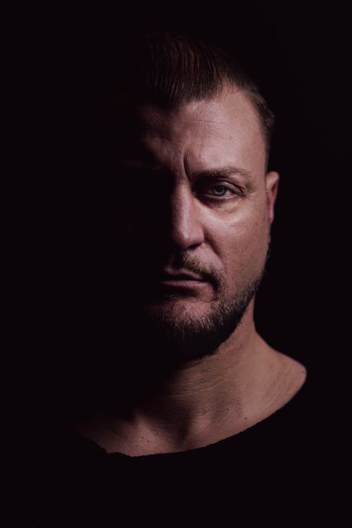 Free Dramatic studio portrait of an adult man with sharp shadows highlighting his features. Stock Photo