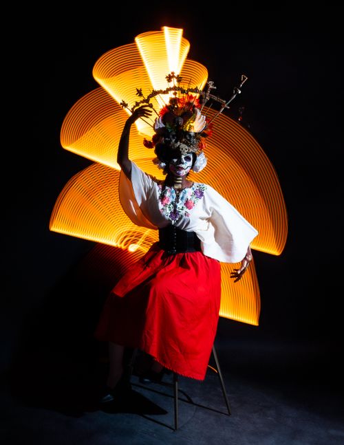 Free Colorful portrait of a woman in traditional Día de Muertos attire with vivid light painting. Stock Photo