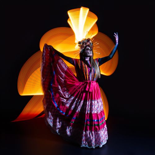 Free Día de Muertos Catrina in traditional attire with vibrant light painting design. Stock Photo