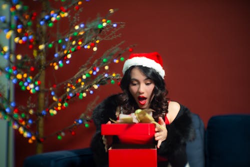 Woman in Santa Hat Sitting with Gift