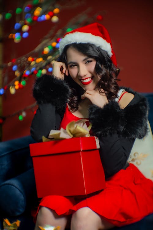 Smiling Woman Sitting with Christmas Gift