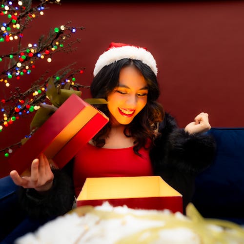 Smiling Woman in Santa Hat Opening Christmas Gift Box