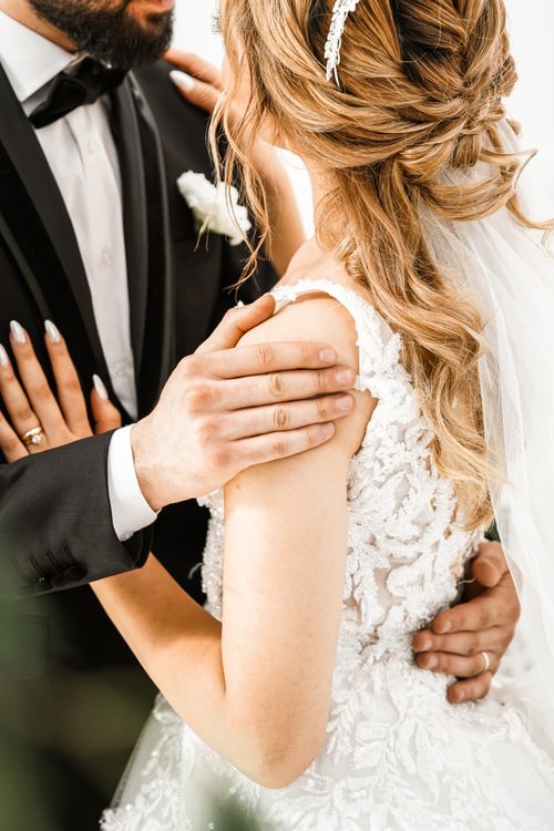 Free Close-up of a stylish couple embracing in wedding attire, showcasing elegance and love. Stock Photo