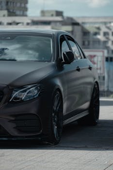 Modern black luxury car captured in a vibrant urban environment in Bucharest, Romania.