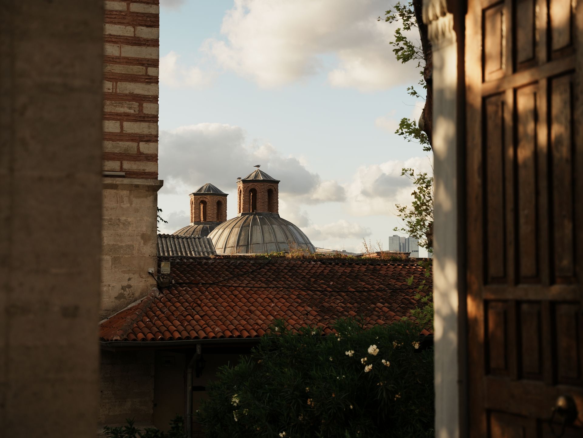 A picturesque view of an ancient bathhouse with domes against a cloudy sky in Bursa, Turkey.