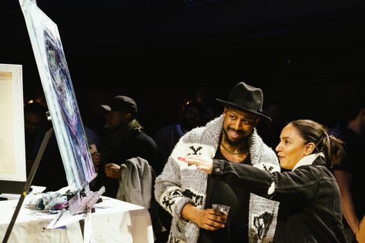 A man and a woman enjoy a vibrant art exhibition in Toronto, Canada.