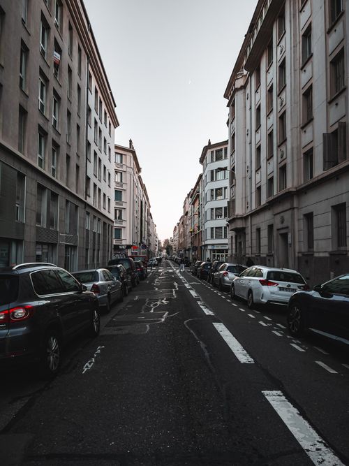 Free Explore a tranquil street in Lyon, France with lined cars and residential buildings, capturing the essence of French urban life. Stock Photo