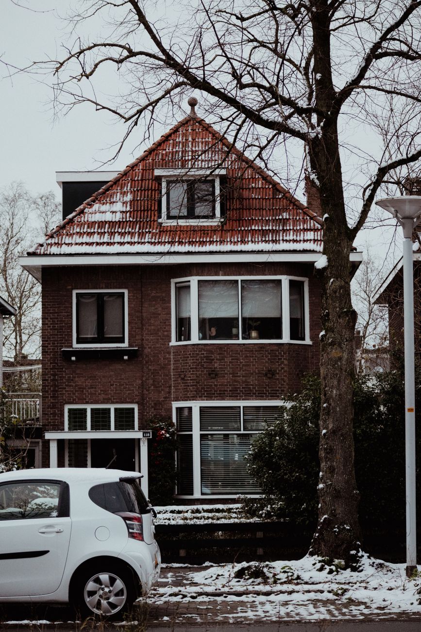 Traditioneel Nederlands bakstenen huis in de buitenwijken van Leeuwarden, Nederland, bedekt met sneeuw in de winter.