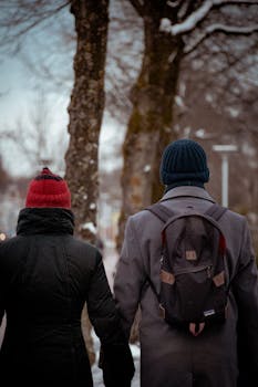 A couple takes a winter walk along a snow-covered path in Leeuwarden, Netherlands.