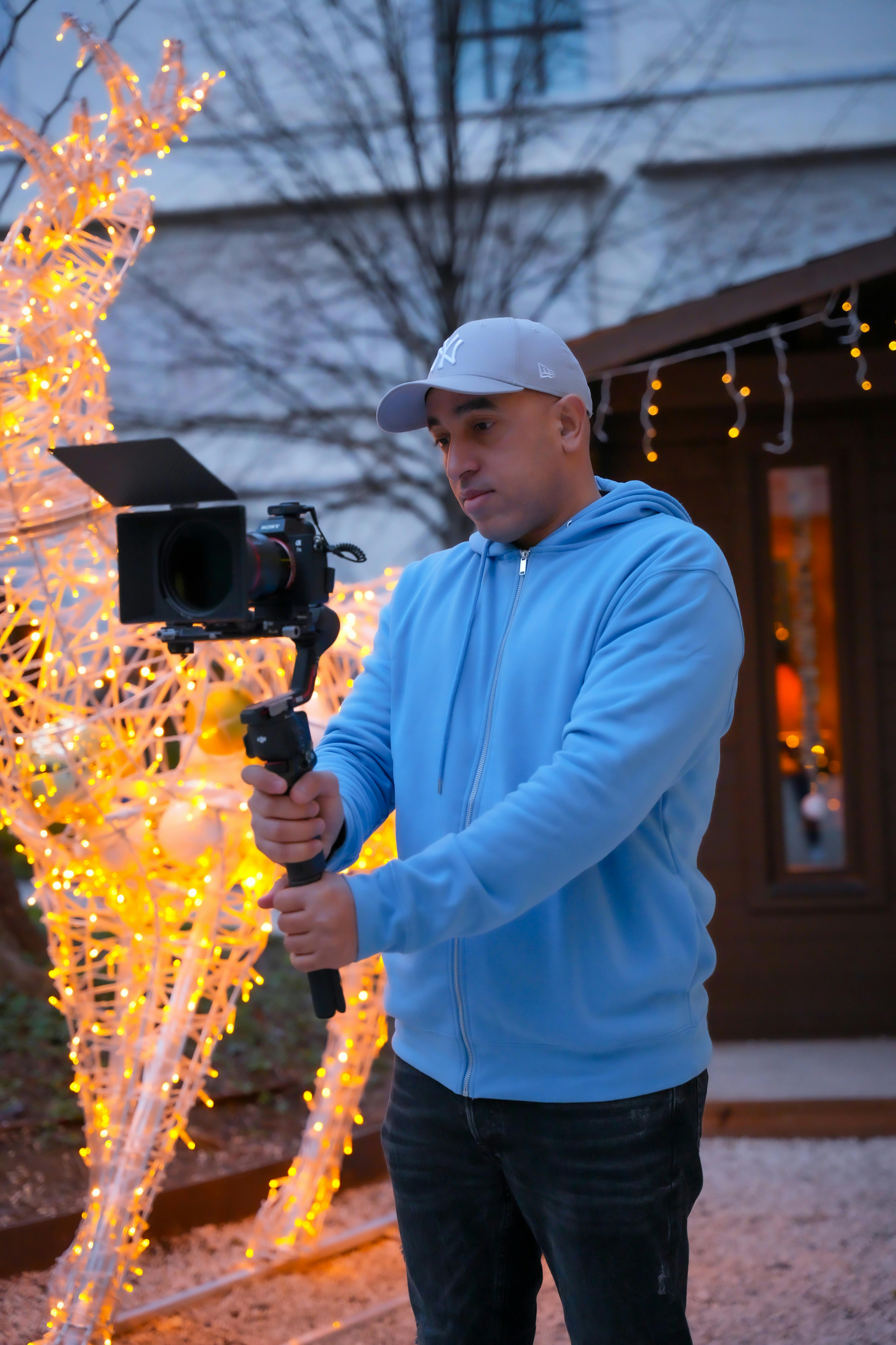 man holding a camera in front of christmas decoration