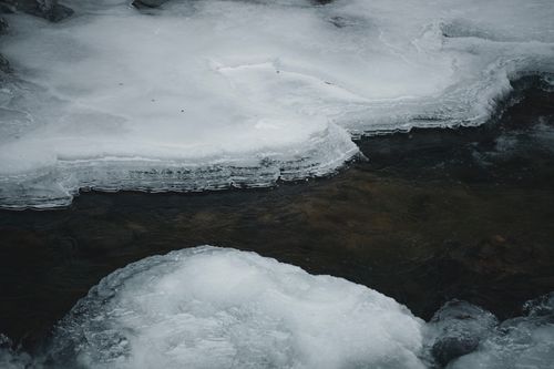 Free Chilly winter scene depicting a frozen river with intricate ice formations. Stock Photo
