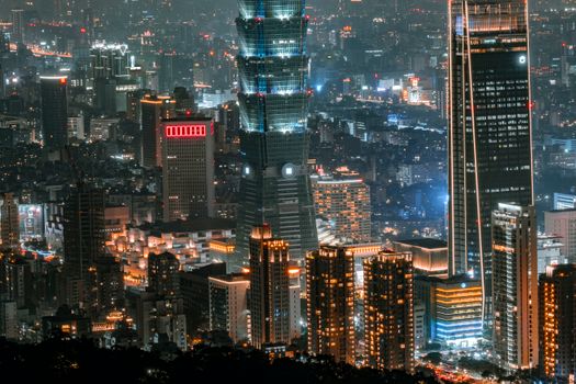 Illuminated Taipei cityscape featuring modern skyscrapers at night, showcasing urban architecture.