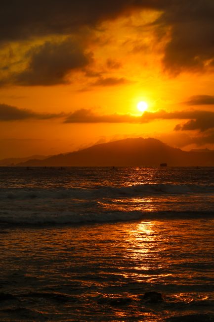 Breathtaking view of a golden sunset casting reflections over calm ocean waves.