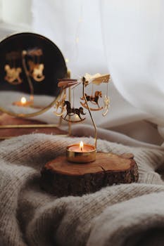 A cozy scene with a carousel tealight and candle on a wooden base, exuding warmth and relaxation.