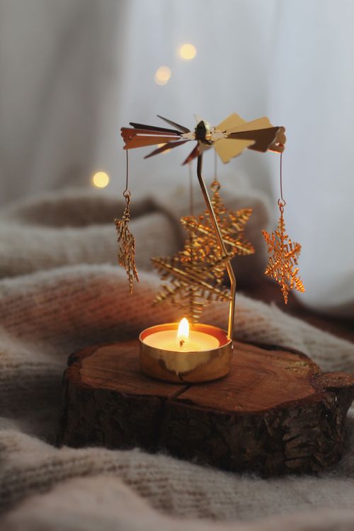 Free Warm candlelight with gold star decorations, perfect for indoor winter ambiance. Stock Photo