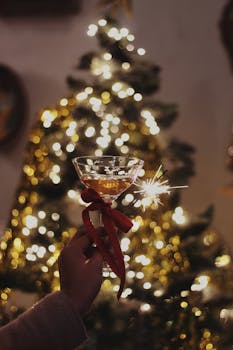Celebrate the holidays with a sparkling toast in front of a beautifully lit Christmas tree.