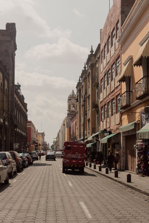 Free A bustling urban street in Puebla, Mexico with classic architecture and a Coca-Cola truck. Stock Photo