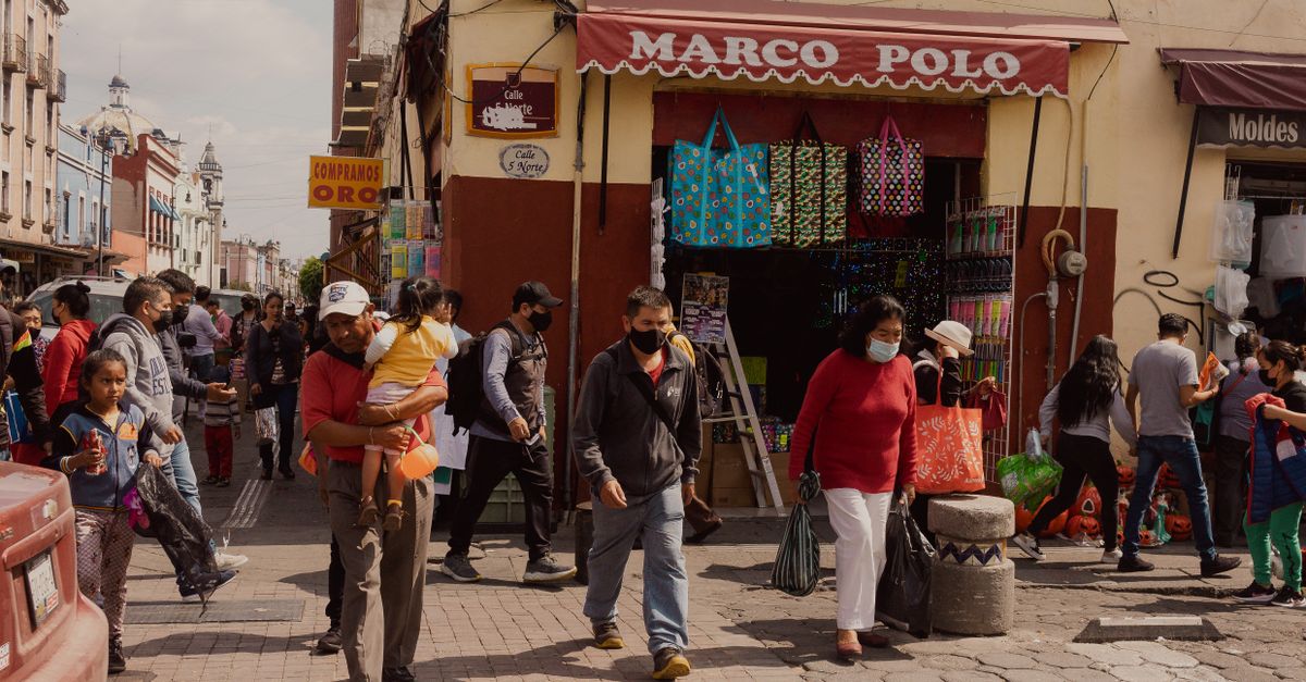 Lively street scene in Puebla, Mexico, capturing urban life with people shopping and walking.
