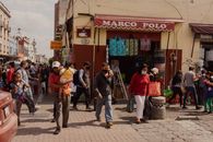 Lively street scene in Puebla, Mexico, capturing urban life with people shopping and walking.