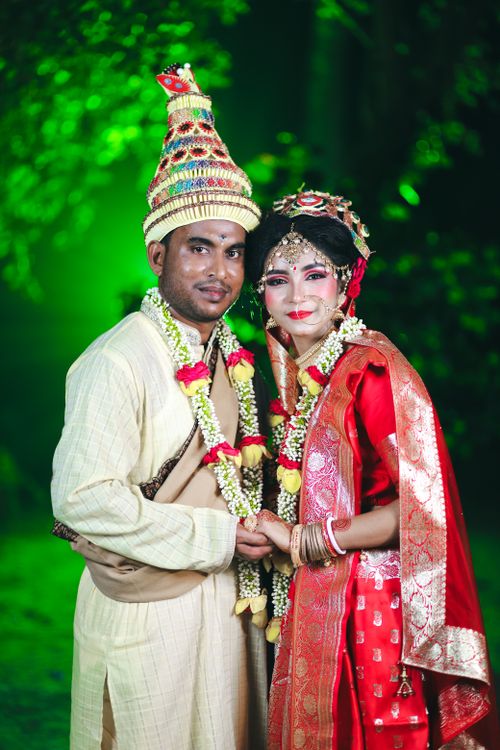 Free Colorful traditional wedding portrait of a couple in ornate ethnic attire holding hands. Stock Photo