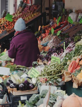 Colorful fruit and vegetable market in Pistoia, Italy with a local vendor.