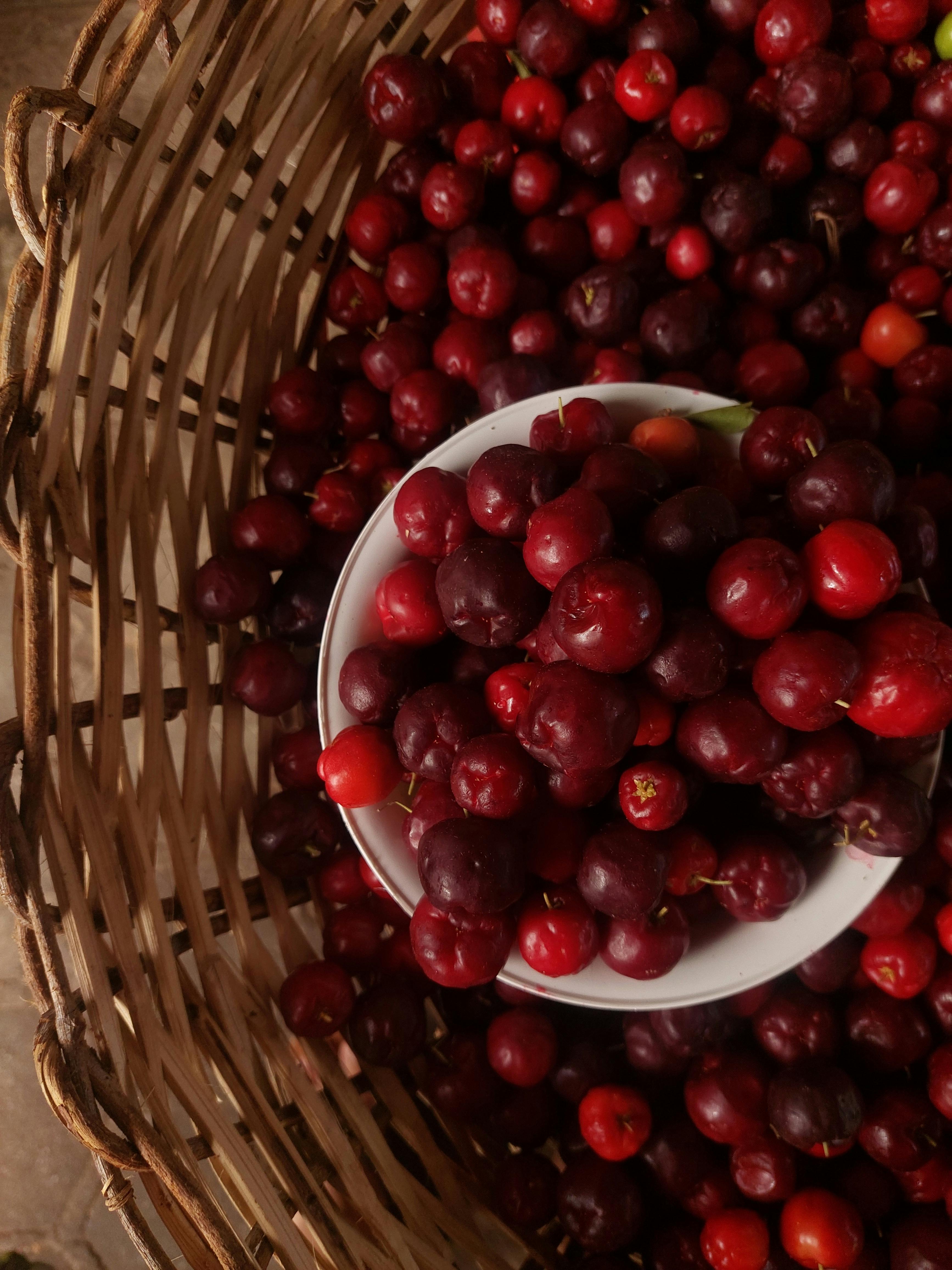 Top view of fresh red cherries in a wicker basket, capturing the essence of abundance and nature.