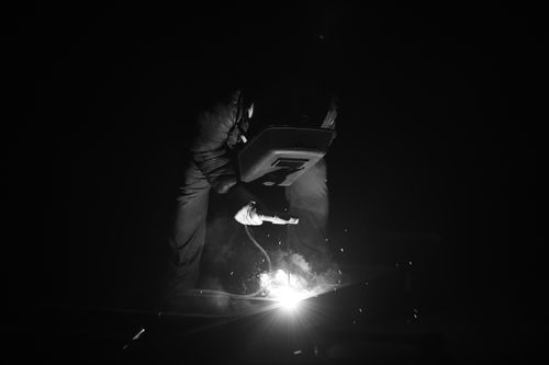 Free Striking black and white image of a welder at work, sparking creativity and craftsmanship. Stock Photo