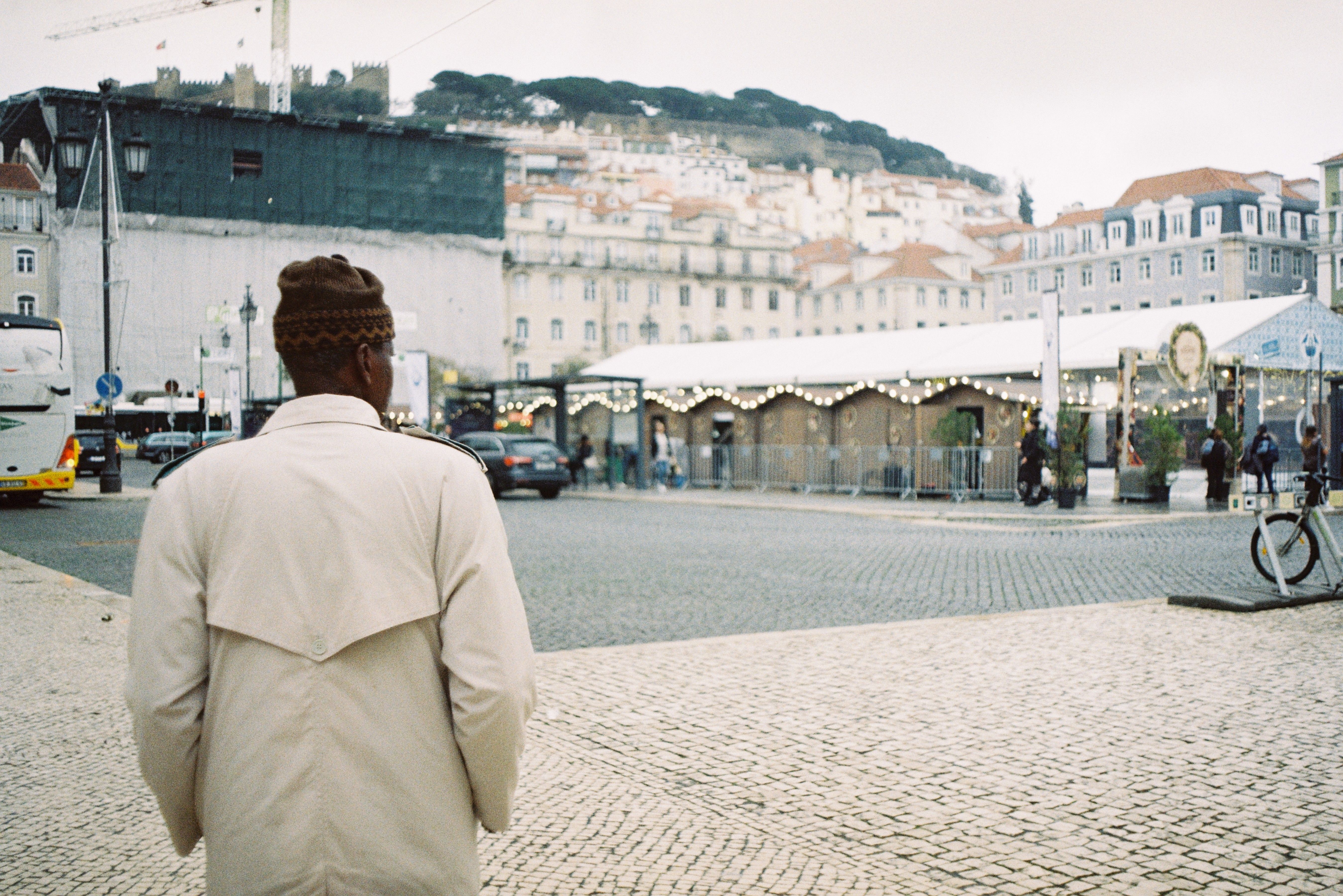 Back View of Man in Trench on Square in City · Free Stock Photo