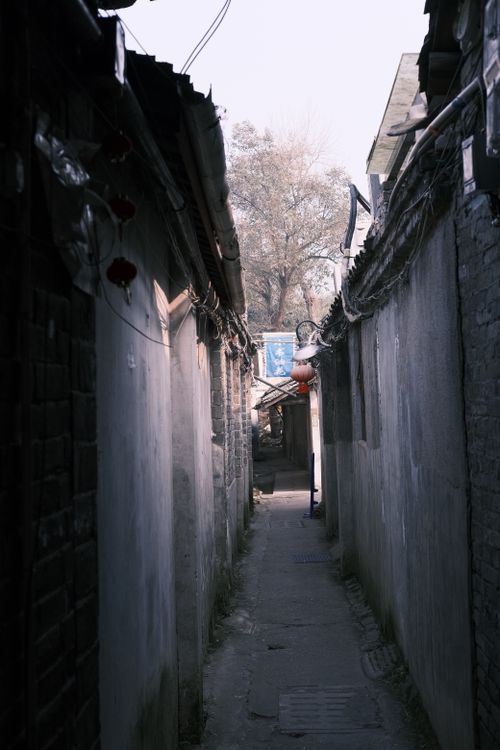 Free Explore a narrow urban alleyway with rustic charm and contrasting shadows. Stock Photo