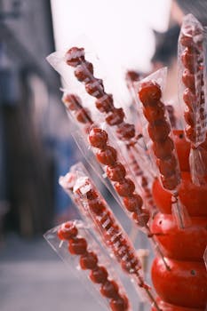 Vibrant street market sweets with sugar-coated candy skewers capturing a delicious urban scene.