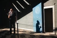 Photo of Man Smoking While Standing Near Roller Shutter